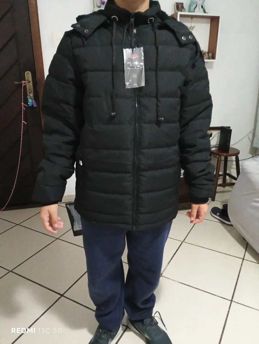 Cliente usando a jaqueta preta em pé, mostrando o caimento completo