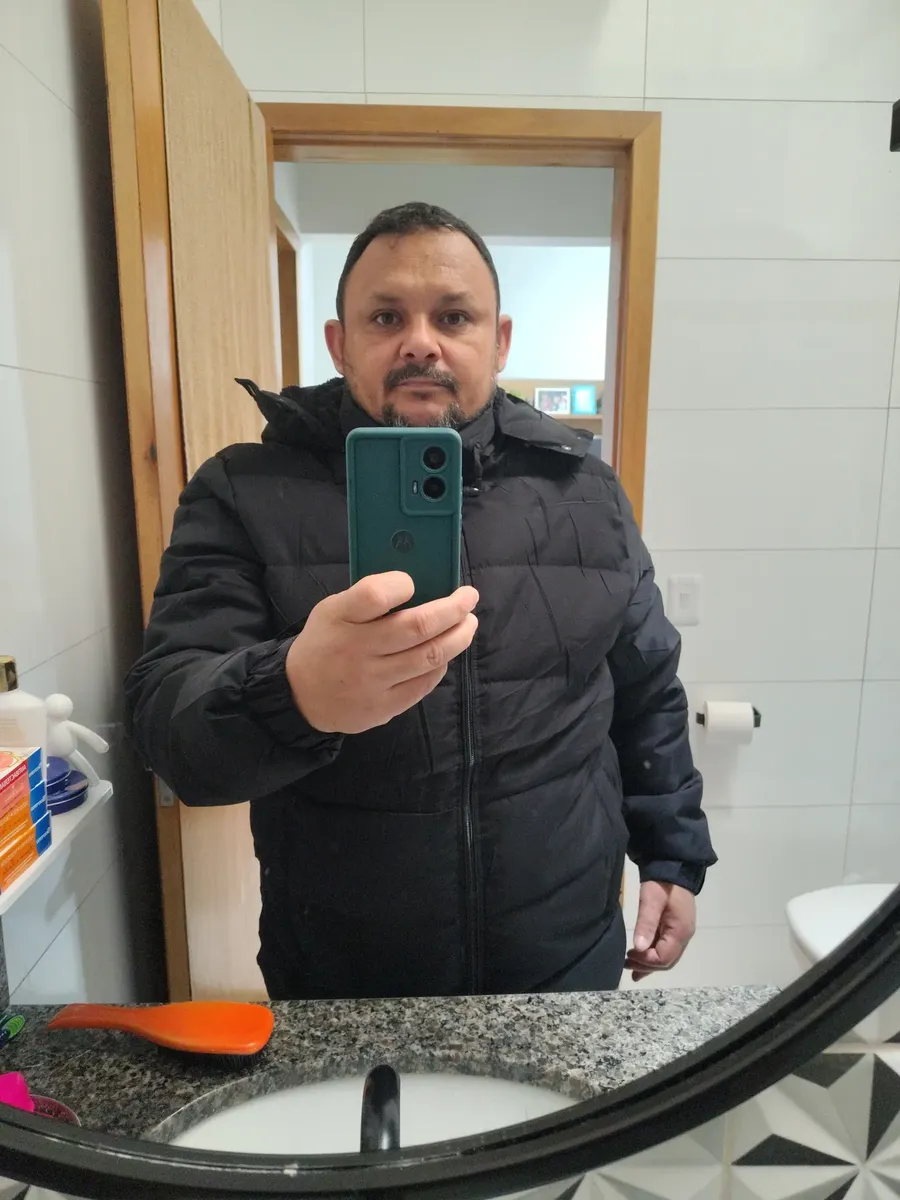 Cliente tirando foto no espelho usando a jaqueta preta